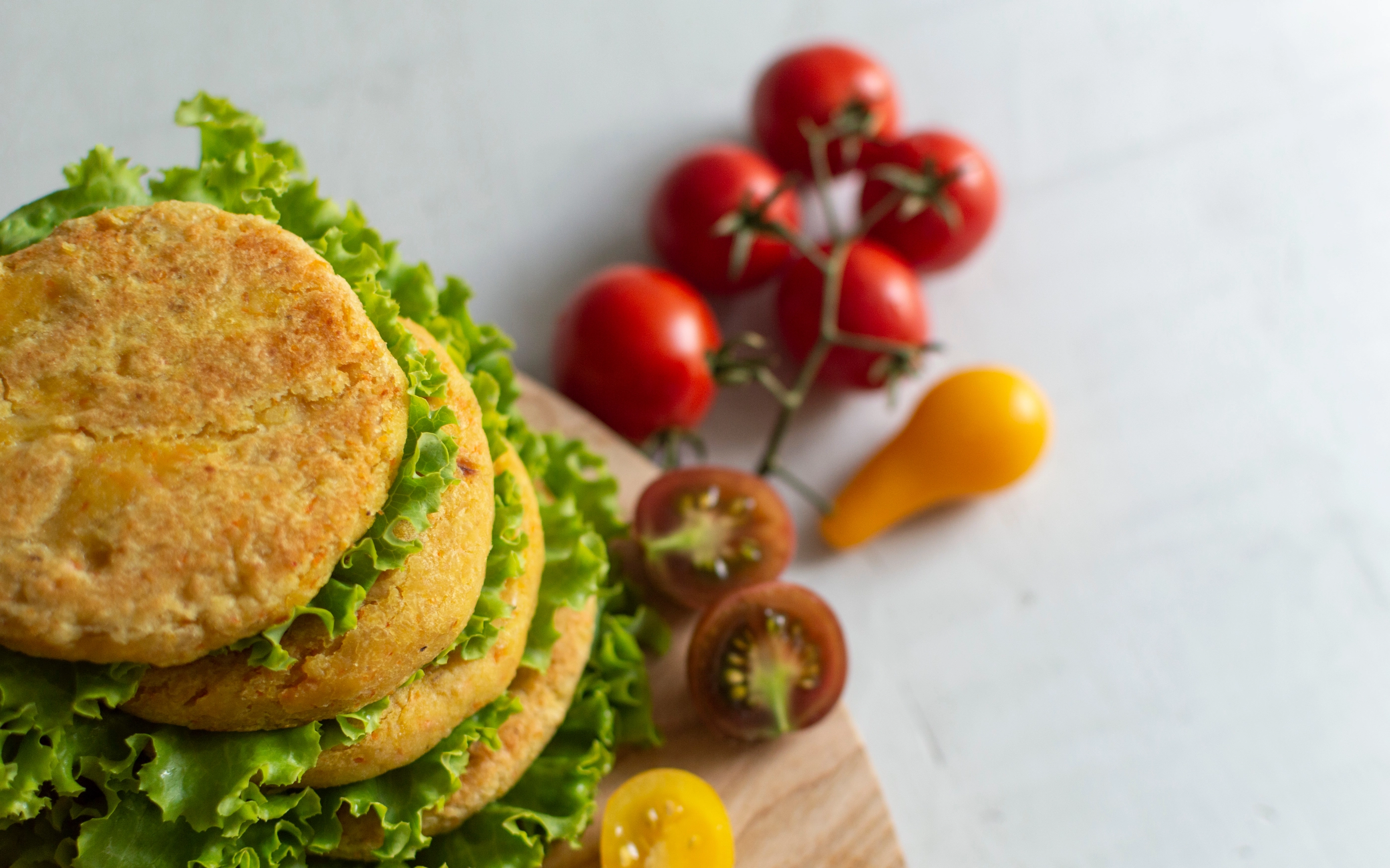 Fresh vegan chickpea burger (cutlets), tomatoes and lettuce. Home made with vegetables and chickpeas.The concept of healthy and vegetarian food. Place for text. Plant based food concept.; Shutterstock ID 1802296072; purchase_order: NFI; job: ; client: ; other: 